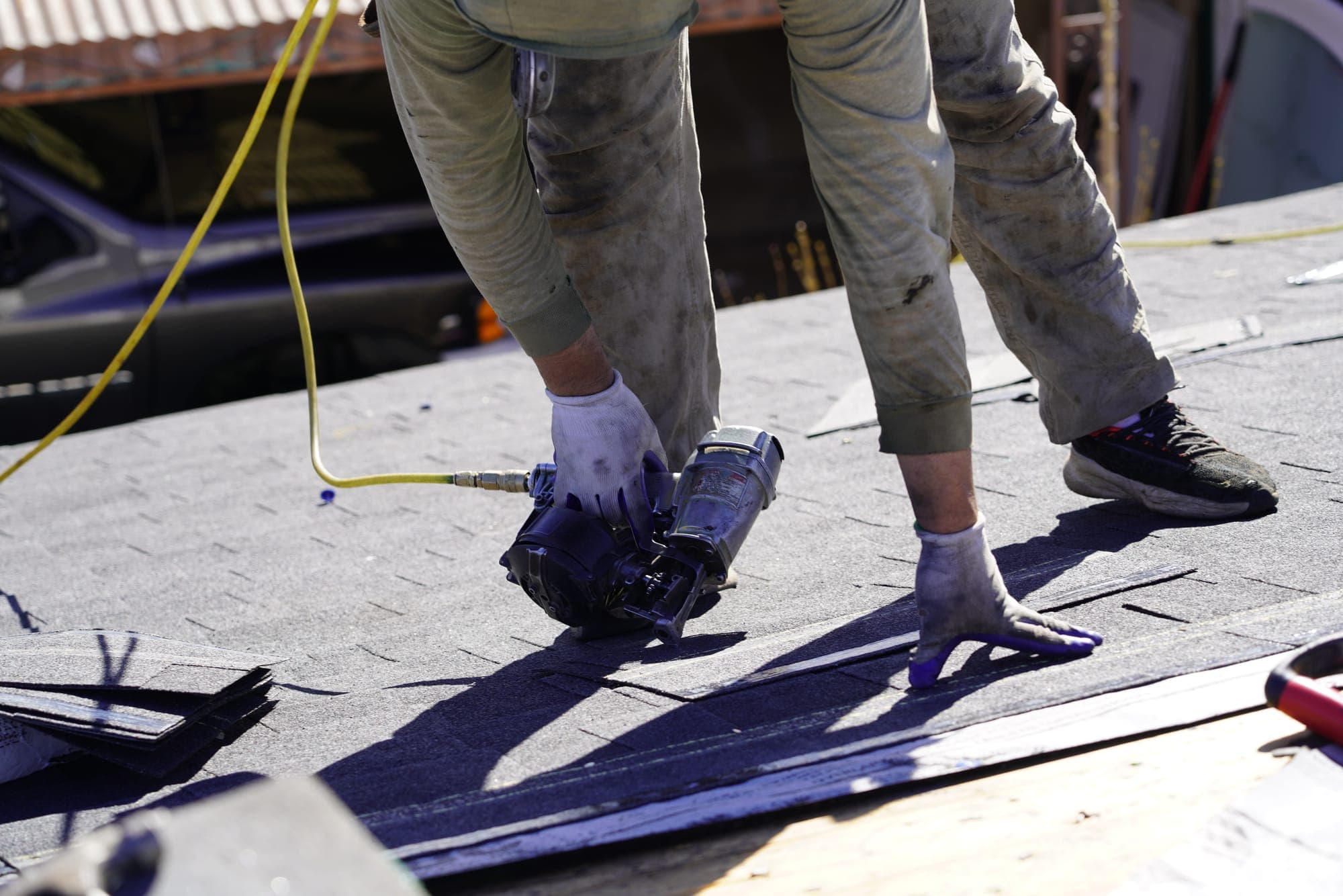 Upstream roofers installing shingles up close