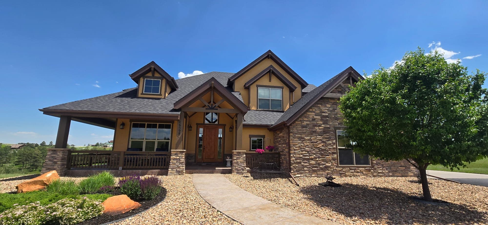 Completed roof on a stone-and-timber craftsman home in Parker, Colorado